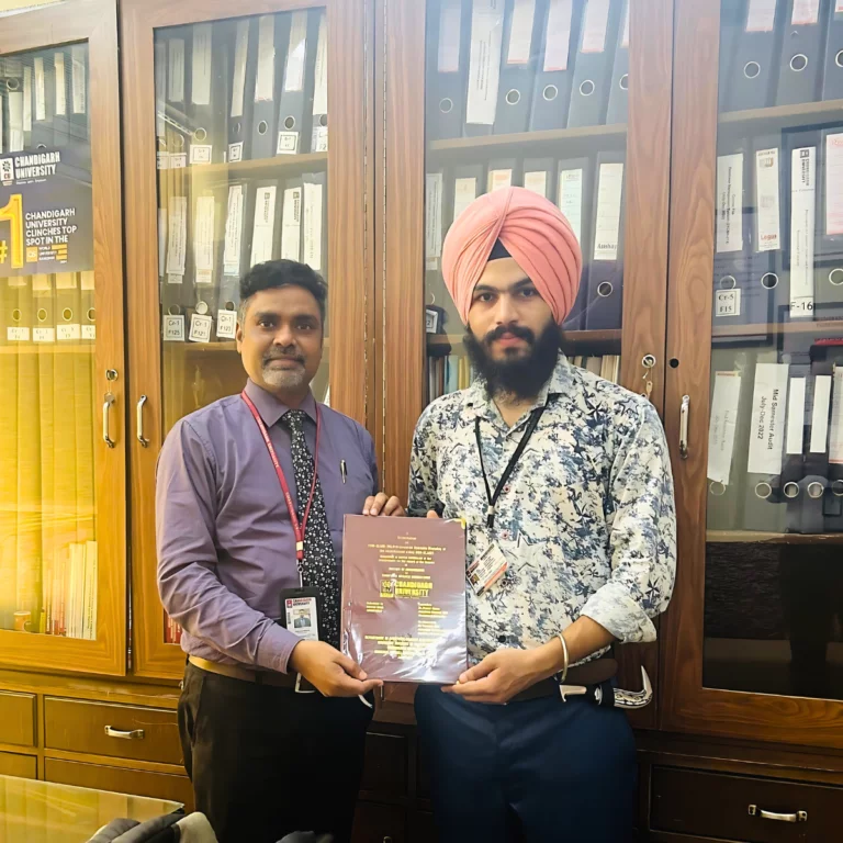 Balveer Singh handing over a copy of his Master's Thesis to Dr. Puneet Kumar of Chandigarh University