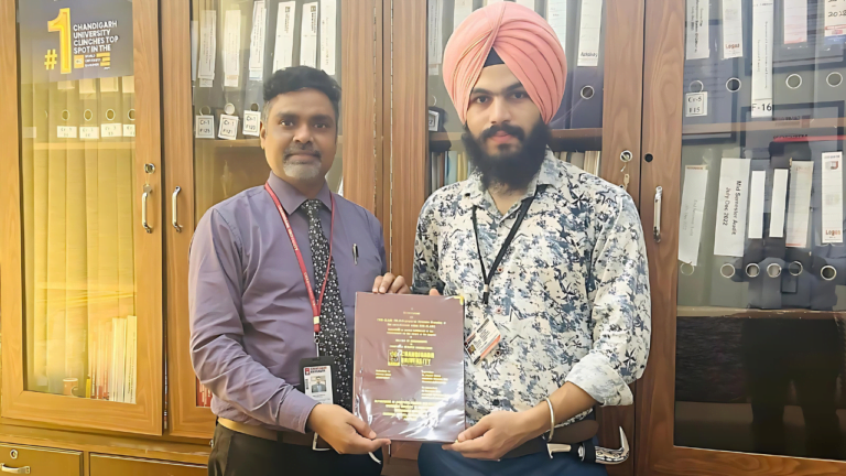 Balveer Singh handing over a copy of his Master's Thesis to Dr. Puneet Kumar of Chandigarh University